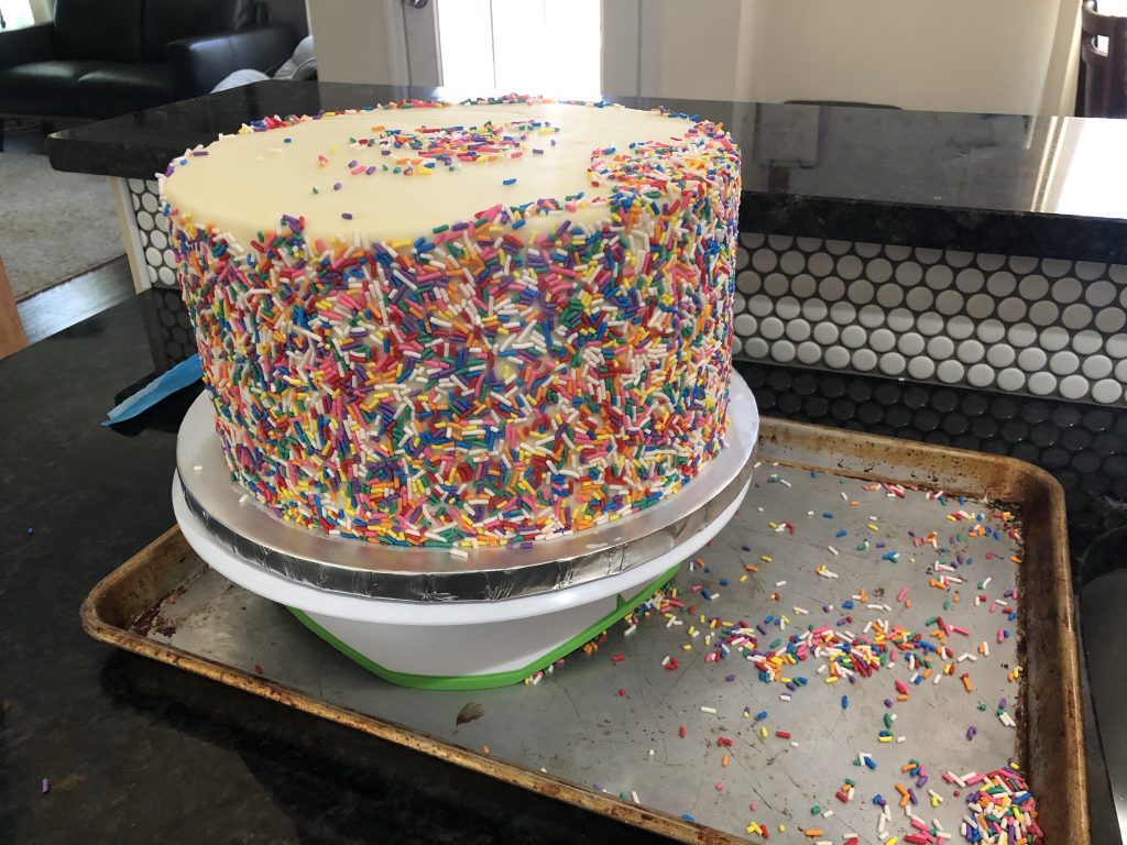 adding sprinkles to sides of cake 