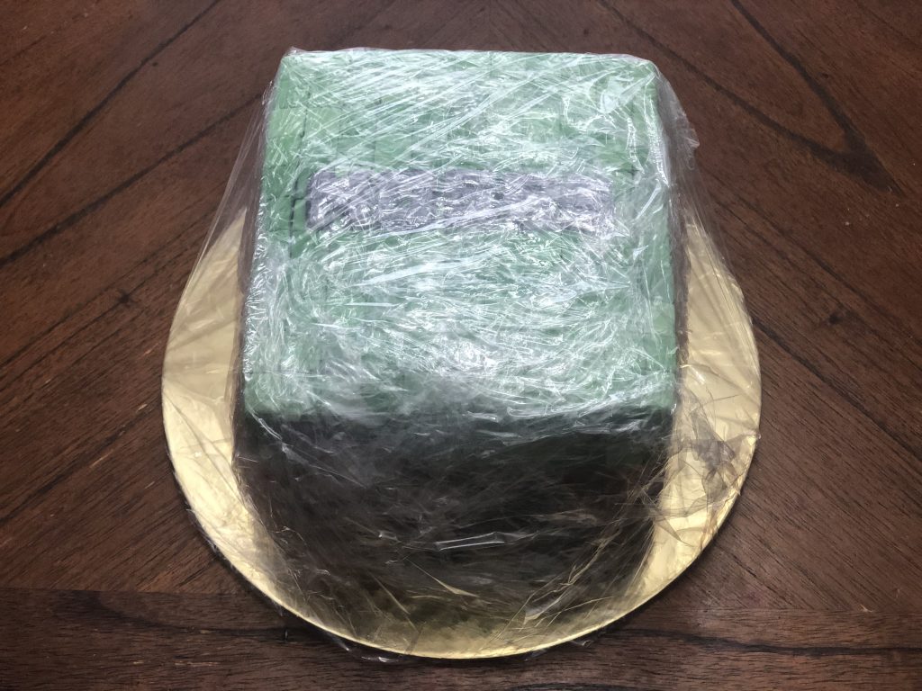 Wrapping a cake in plastic wrap. 